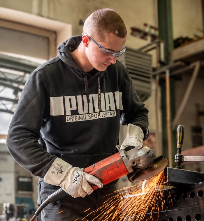 Lehrling bei Metallbau Saller bei einer handwerklichen Tätigkeit mit Schutzausrüstung